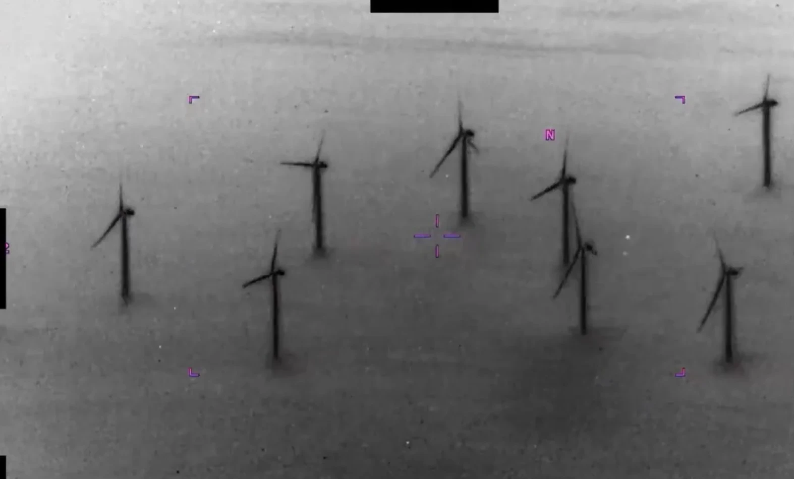 Grayscale aerial view of wind turbines with purple targeting marks